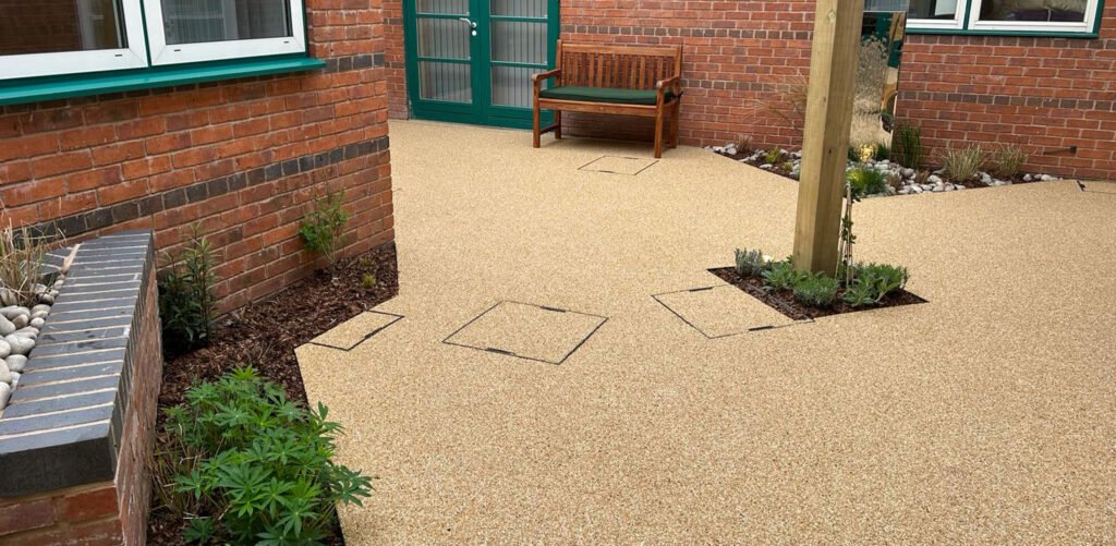 Acorn Hospice in Walsall Commercial Landscaping Project - Resin footpaths, wooden garden structure, outdoor pergola. New planting plan and flower beds. Resin pathways and chrome water feature. Wooden benches.