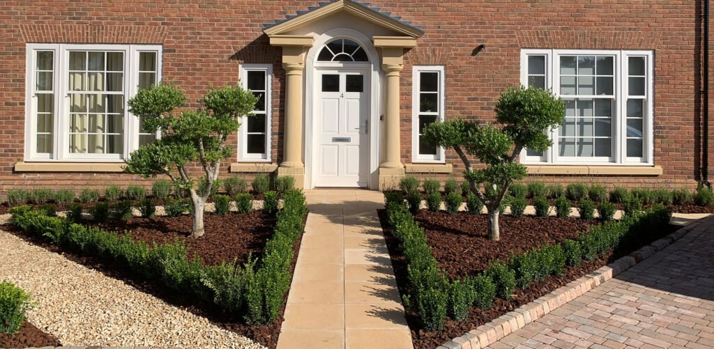 Taylor Landscape and Design Luxury Residential Landscaping Project - Planting beds, stone and brick driveway. Custom Olive tree planted on left and right.