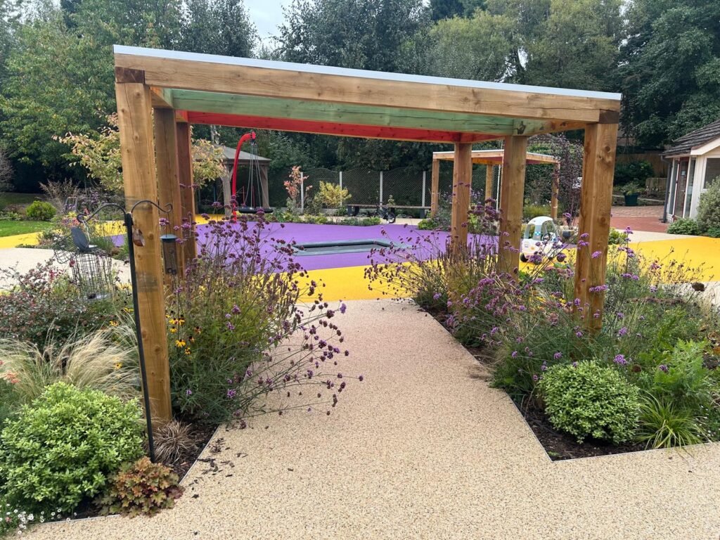 Acorn Hospice in Walsall Commercial Landscaping Project - Resin footpaths, wooden garden structure, outdoor pergola, climbing frames, new turf. New planting plan and flower beds. Stone paths way and patios. Custom made timber pergola
