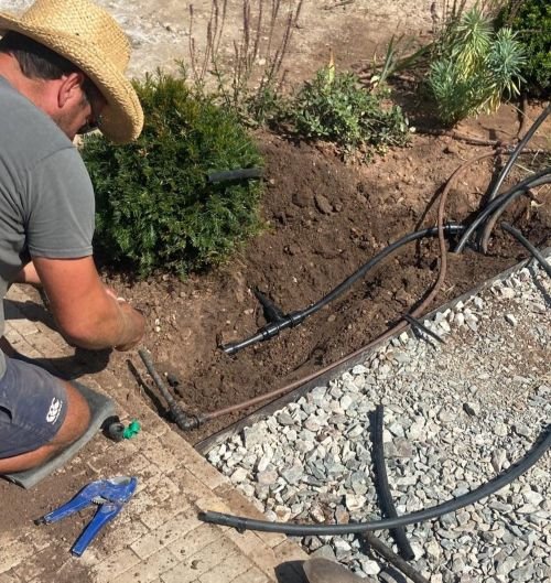 Chris putting in irrigation system for raised flower bed