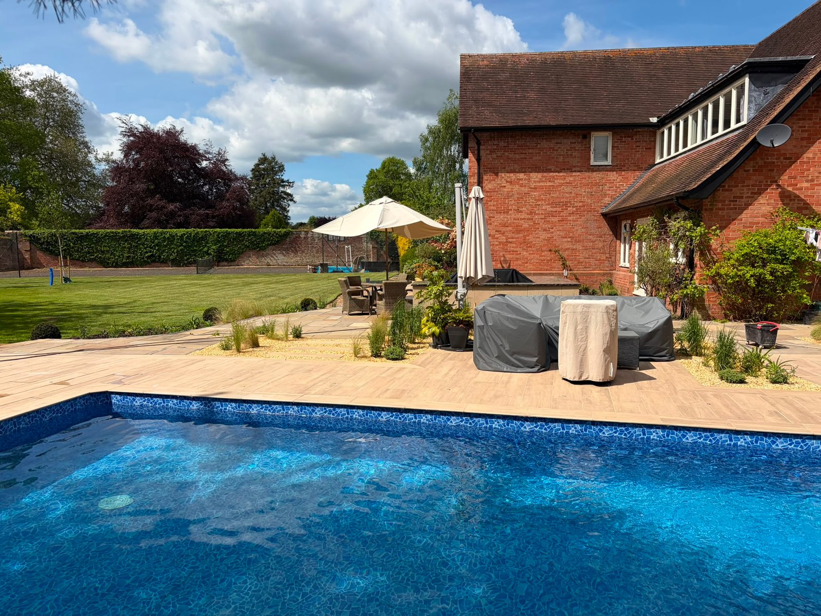 garden re-design where we replaced fencing, made a gate, built a pool, porcelain patio, slabbed patio, planting trees and 200+ other plants, path creation, bbq area created, slopes re-graded and seeded, birch tress planted, custom garden lighting
